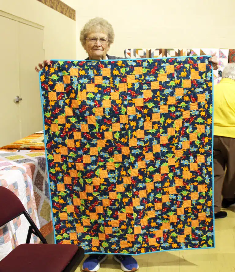 Associate Mary Teder was the first winner, choosing the Dino Babies quilt. Associate Mary Teder was the first winner, choosing the Dino Babies quilt.