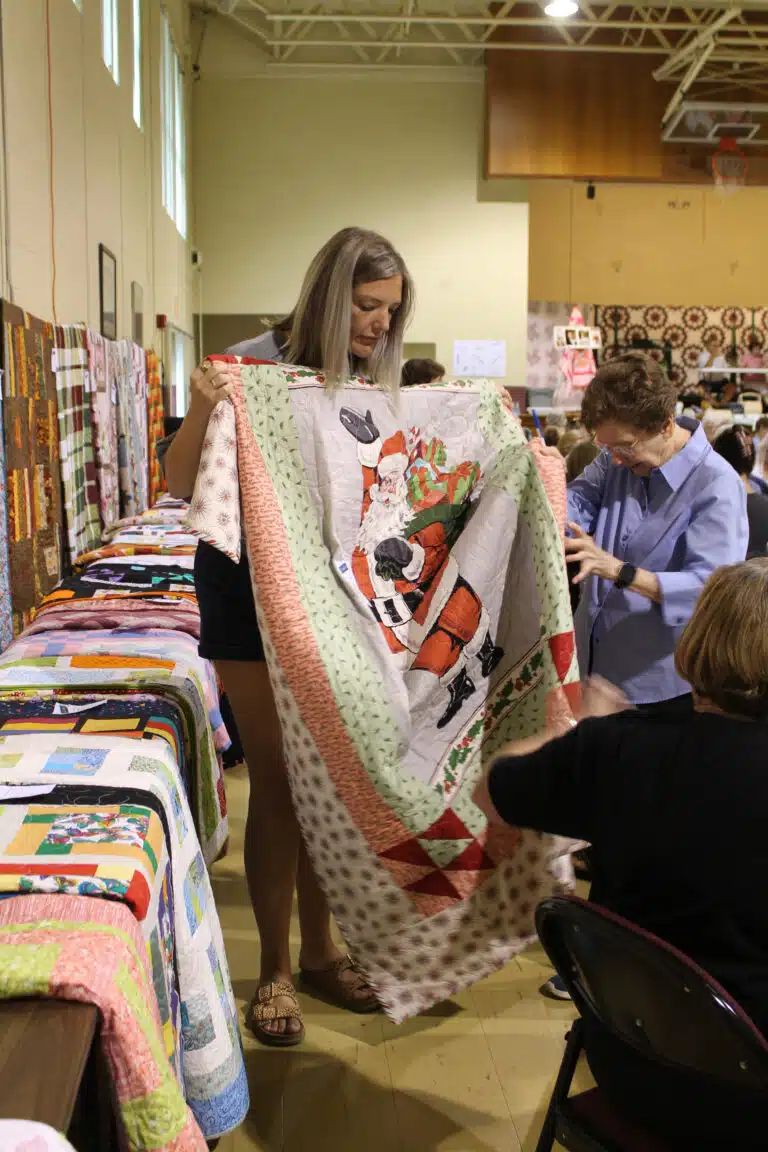 Hannah Martin of Owensboro was the winner of game 11, and she got in the holiday spirit with the “Santa’s Coming” quilt. Sister Mary Henning helps hold the quilt. Hannah Martin of Owensboro was the winner of game 11, and she got in the holiday spirit with the “Santa’s Coming” quilt. Sister Mary Henning helps hold the quilt.