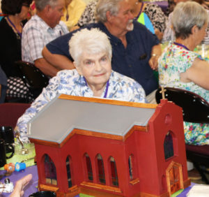 Betty Rumage Bickett ponders where she’s going to put this birdhouse that is a replica of the Motherhouse Chapel. It was created by Stephanie Warren and Sue Batman, and was one of the major door prizes, which Bickett won.