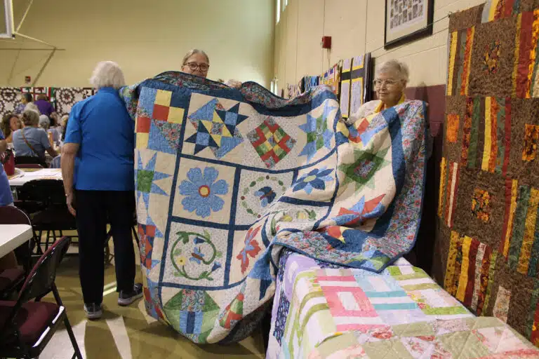 Jolena Smith of Utica loved the “Nature’s Stars” quilt that she won. Sister Jane Falke, right, is helping her hold it. Jolena Smith of Utica loved the “Nature’s Stars” quilt that she won. Sister Jane Falke, right, is helping her hold it.
