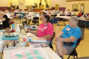 Janie Blalock of Georgia, left, and Nylene Henry of Florida look at quilt patterns on a computer.