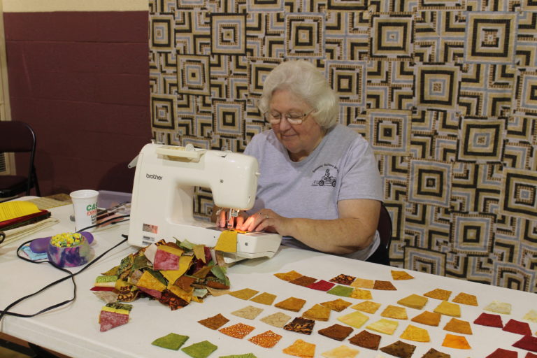 Brenda Coffey of Bowling Green, Ky., smiles as she works on a double wedding ring quilt. She is a retired teacher who has been to every Runaway retreat except one since 2001.