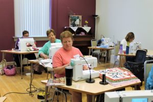 Participants in a Christmas wall hanging class, including Rosemary Krampe of Owensboro, Ky., front, work on their own variation of the project in a room at the Conference and Retreat Center.