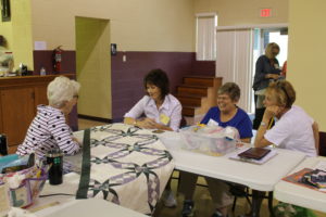 Some of the quilters share a laugh in the gym on Wednesday afternoon. Pictured, left to right: Nell Jordan of Franklin, Ky., Ann Mason of Springfield, Tenn., Margaret Scott of Island, Ky., and Julie Quisenberry of Calhoun, Ky.