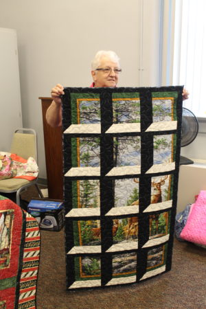 Pat Hall of Pavo, Ga., holds up her Attic Window quilt.