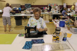 Sue Dee of Williamsburg, Ky., smiles as she quilts in the Mount gymnasium.