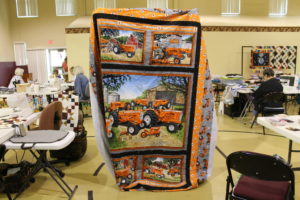 Ann Mason of Springfield, Tenn., holds up an Allis-Chalmers tractor quilt that she was hand-quilting in honor of her father. She said it took her a long time to find the fabric.