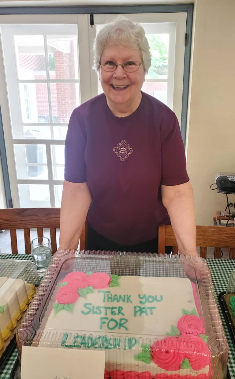 Sister Pat Lynch, assistant congregational leader, is all smiles with her cake. She also served in elected office when she was an Ursuline of Paola, Kan.