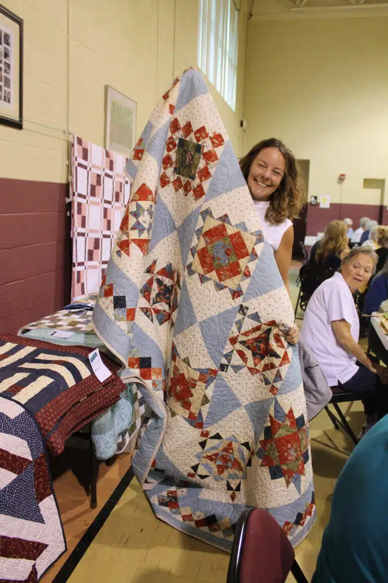 Jacqueline Stogsdill of Owensboro was nearly hidden by her beautiful new “Blues-A-Blooming” quilt. Jacqueline Stogsdill of Owensboro was nearly hidden by her beautiful new “Blues-A-Blooming” quilt.