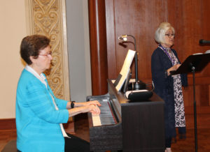 Sister Mary Henning, A64, plays the piano as Jennifer Speaks McGee, A’70, leads the congregation in “Sing a New Song.”