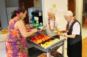 Sister Clarita Browning, right, and Sister Mary Irene Cecil, center, help Debbie Dugger make the sisters plates filled with pineapple, grapes, cantaloupe and strawberries.