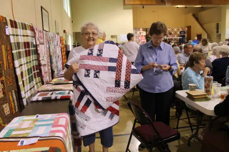 Linda Carter of Louisville was one of two people who got bingos in game 7. She was happy with her new “Hurray for America” quilt. Sister Mary Henning, right, was writing down her information. Linda Carter of Louisville was one of two people who got bingos in game 7. She was happy with her new “Hurray for America” quilt. Sister Mary Henning, right, was writing down her information.