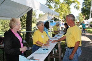 Ursuline Associates Lois Bell, left, and Elaine Wood speak with Mike Coomes at the Volunteer Sign-In booth. Mike, who is Sister Alicia’s brother, was in charge of trash and recycling.