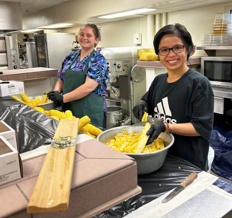 Amanda Geary, left, of the Mount Food Service staff, and Sister Chanh, a Vietnamese sister who was helping for the day, cut corn off the cob in the Mount kitchen. Amanda Geary, left, of the Mount Food Service staff, and Sister Chanh, a Vietnamese sister who was helping for the day, cut corn off the cob in the Mount kitchen.