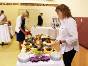 Associate Doreen Abbott, right, volunteered for the gala, here helping keep the appetizer table filled.