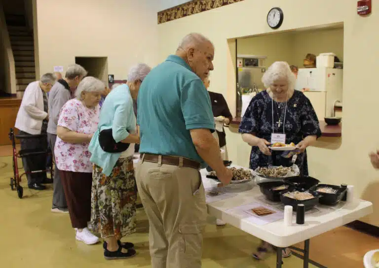 Sister Vivian Bowles, right, smiles as she fixes her plate for lunch, as Associate Ed Cecil across from her looks over the desserts. Sister Vivian Bowles, right, smiles as she fixes her plate for lunch, as Associate Ed Cecil across from her looks over the desserts.
