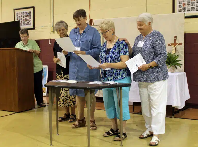During the ceremony for new Associates, Amy Fogle Stiff, second from left, and Gayle Sims Bogard, third from left, read their commitments. Their contact companions, Sister Cheryl Clemons, left, and Sister Suzanne Sims, right, witnessed their commitments. During the ceremony for new Associates, Amy Fogle Stiff, second from left, and Gayle Sims Bogard, third from left, read their commitments. Their contact companions, Sister Cheryl Clemons, left, and Sister Suzanne Sims, right, witnessed their commitments.