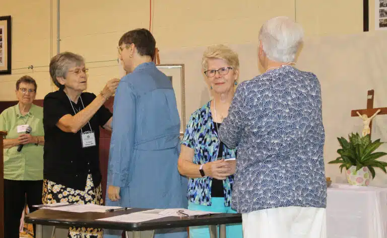Sister Cheryl Clemons, left, pins new Associate Amy Fogle Stiff as new Associate Gayle Sims Bogard is pinned by Sister Suzanne Sims. Congregational Leader Sister Sharon Sullivan, back left, led the ceremony. Sister Cheryl Clemons, left, pins new Associate Amy Fogle Stiff as new Associate Gayle Sims Bogard is pinned by Sister Suzanne Sims. Congregational Leader Sister Sharon Sullivan, back left, led the ceremony.