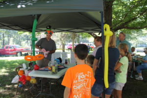 Wiggles the Clown (Will Wigginton) makes balloon sculptures at the picnic.