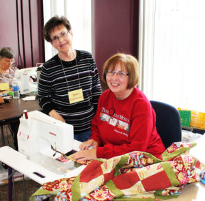 Jane Blankenship, left, and her sister-in-law Karen Hayes work on their Two’s Company queen size quilt top.