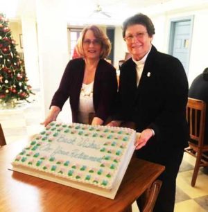 Sister Amelia Stenger, right, congregational leader of the Ursuline Sisters, poses with Jackie and her cake, which read, “Best wishes on your retirement.”