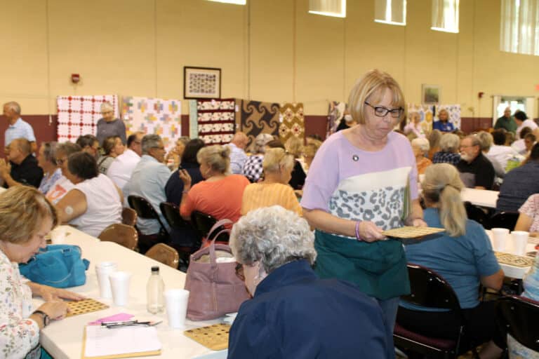 Ursuline Associate Alice Durbin prepares to take a bingo card up front to make sure it’s a real bingo winner. She was selling bingo cards at that table.
