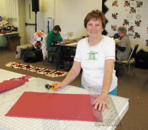 Carolyn Salsman works on a binding for a quilt she completed.