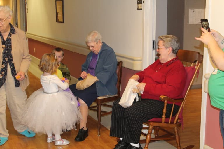 Sister Marie Montgomery, center, and Sister Rose Jean Powers, right, are delighted to see “Snow Princess” Amelia and “Dinosaur” Kaiser at the Halloween party.