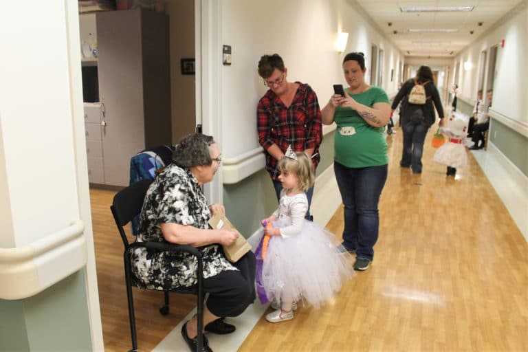 Sister Lois Lindle, left, talks to trick-or-treater Amelia, dressed as a snow princess.