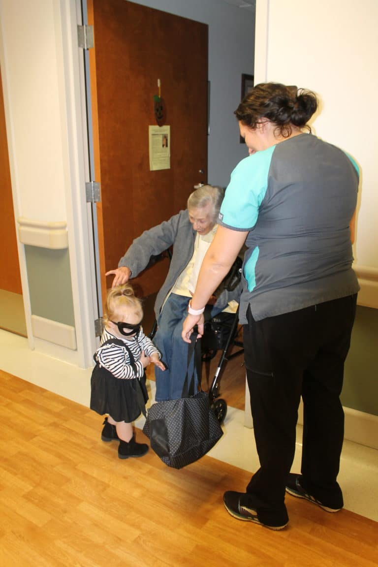 Sister Marietta Wethington is happy to give candy to “Robber” Stella as her Mom, Jordan Berry, watches.
