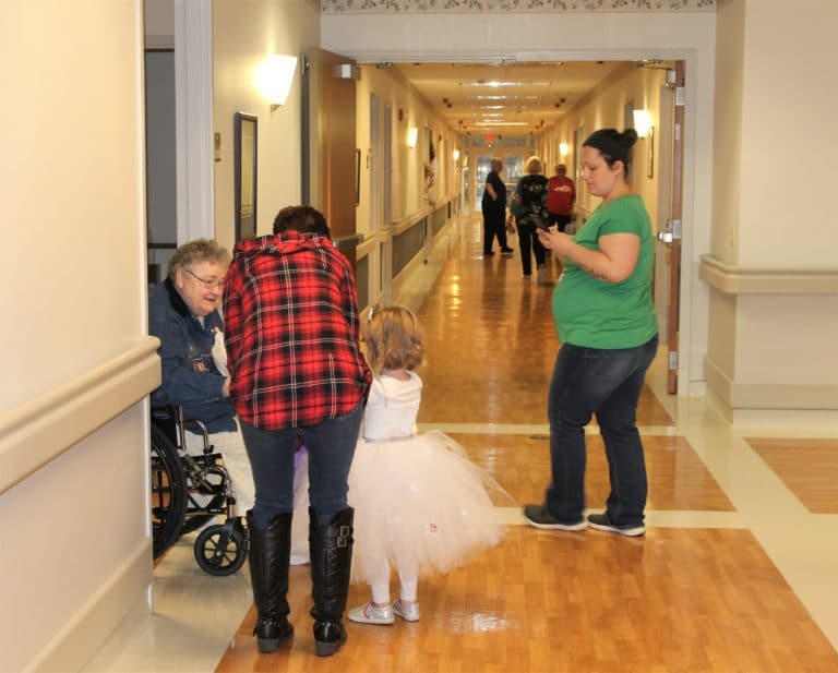 “Snow Princess” Amelia, granddaughter of Mary Allen who works in Housekeeping, gets candy from Sister Joyce Marie Cecil.