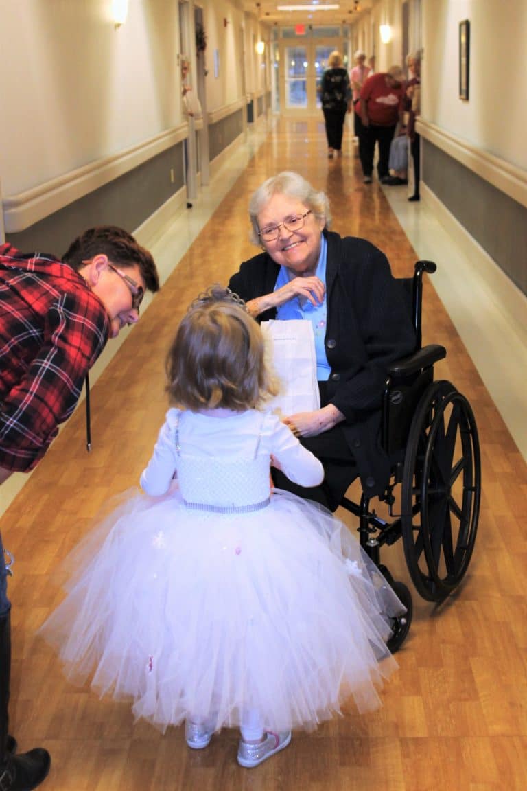 Sister Pat Rhoten smiles as she hands candy to “Snow Princess” Amelia.