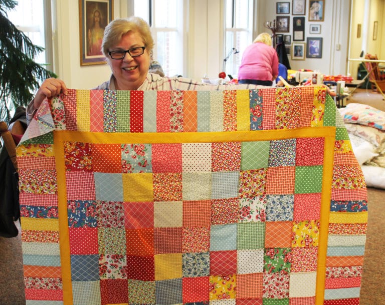 Cindy Thompson, who lives near Memphis, Tenn., holds up the table runner she completed on Feb. 24.