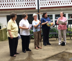 The sisters encircled the courtyard at the Retreat Center on the evening of July 14 to complete their Chapter of Affairs meeting during Community Days. Sister Mary Ellen Backes, right, leads the prayer service as Sister Monica Seaton holds a bowl of prayers and reflections from the sisters that were gathered during the three days. Sister Pam Mueller holds the cross. Sister Amelia Stenger is next to her, with Sister Sharon Sullivan at left.