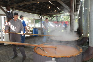 Volunteers stir large pots of burgoo that will be served by the cup and sold by the gallon.