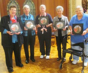 The outgoing leadership Council poses with the presents they received on behalf of the Ursuline community on July 12. Sister Mary Diane Taylor, an art professor at Brescia University, made each of the Council members a framed photo of the Motherhouse Chapel with an inscription that reads “Proclaiming the Lord with the Joy and Witness of Our Lives.” From left are Sisters Sharon Sullivan, Julia Head, Rita Scott, Nancy Murphy and Kathleen Dueber.
