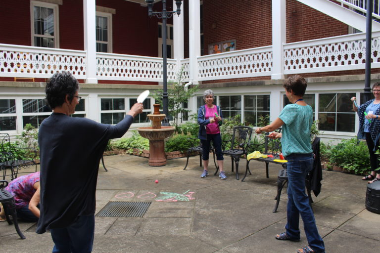 Heather Berndt, left, and Maryann Joyce, third from left, play with paddle balls as Karen Stewart, center, and Lea Vollmer, right, use bubble wands.