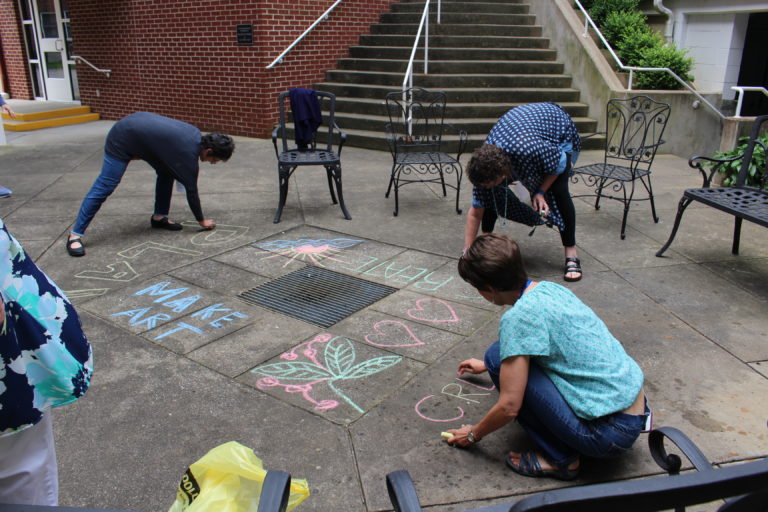 Left to right, Heather Berndt, Lea Vollmer and Maryann Joyce decorate the courtyard with sidewalk chalk.
