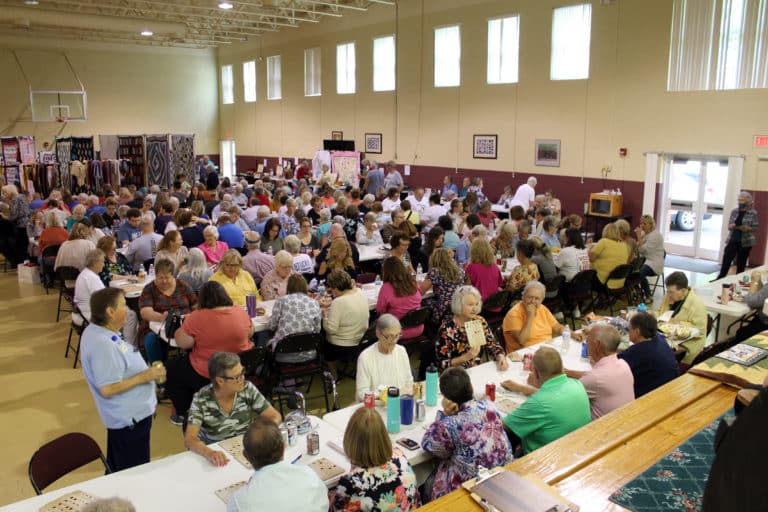 Sister Alicia Coomes, standing at left, looks over the full house in the Mount Saint Joseph Auditorium for Quilt Bingo.