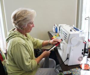 Deb Rutherford works on a quilt for her late friend’s grandson.
