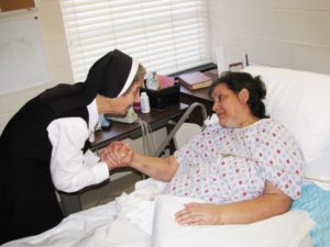 Sister Rose Karen shares some encouraging words with Deborah Legrand after saying the Lord’s Prayer with her. 