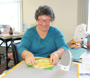 Dee Eggers works on a piece for her table runner that will feature ladybugs.