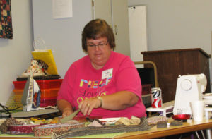 Faith Bratton, of Paducah, Ky., works on 1 ½-inch strips of fabric during the Granny Square class.