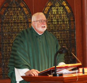 Father Ray Goetz, chaplain at Maple Mount, reads from the Gospel of Luke.