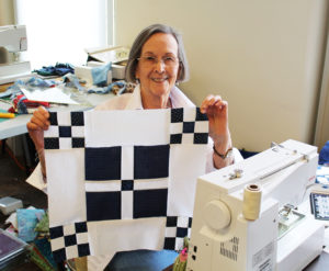 Faye Kirtely holds a block of the Burgoyne Surrender quilt she was making.