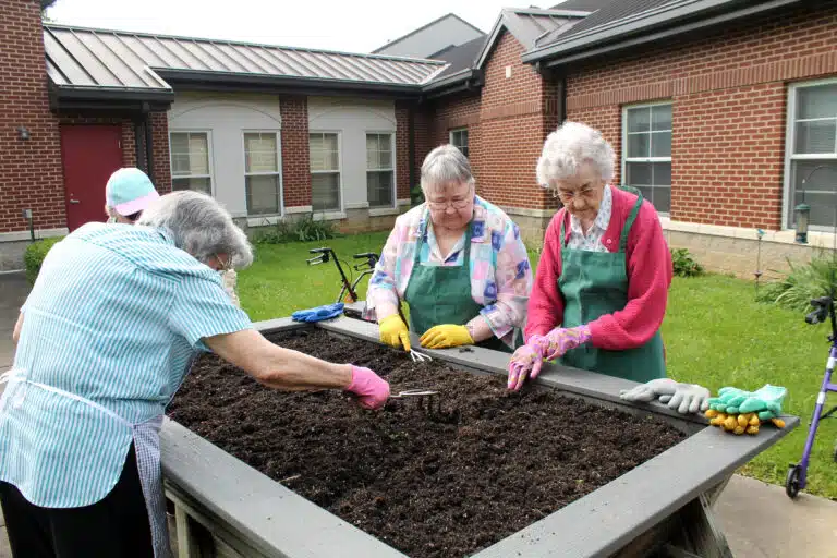 Left to right, Sister Luisa Bickett, Sister Marie Joseph Coomes, Sister Joyce Cecil and Sister Mary Gerald Payne donned aprons and gloves to prepare the raised bed.