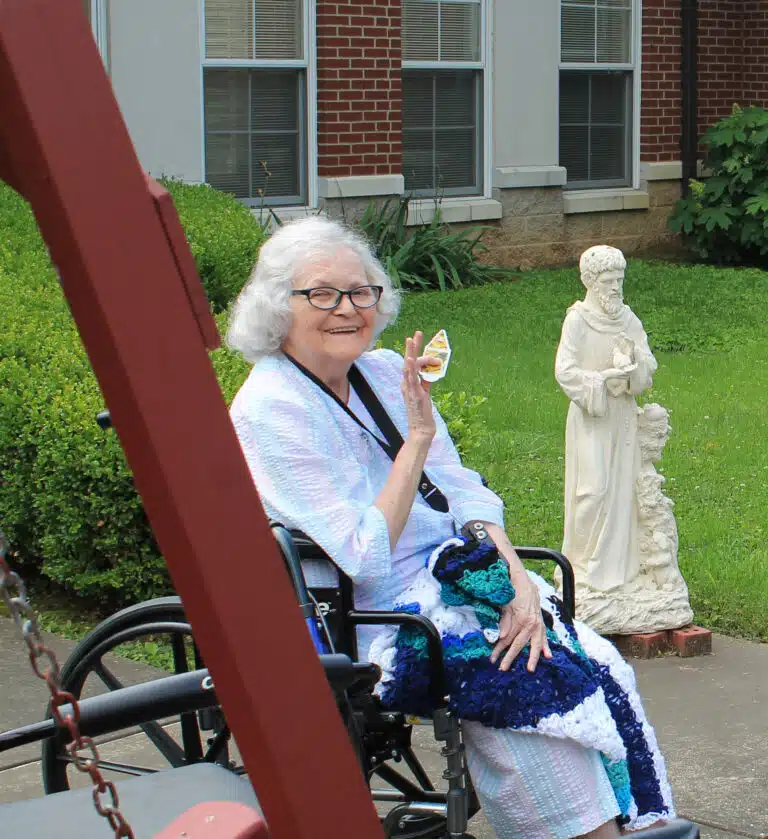 Sister Pat Rhoten smiles and waves after coming out to oversee the flower planting. She also took some pictures of the activity. Sister Pat Rhoten smiles and waves after coming out to oversee the flower planting. She also took some pictures of the activity.