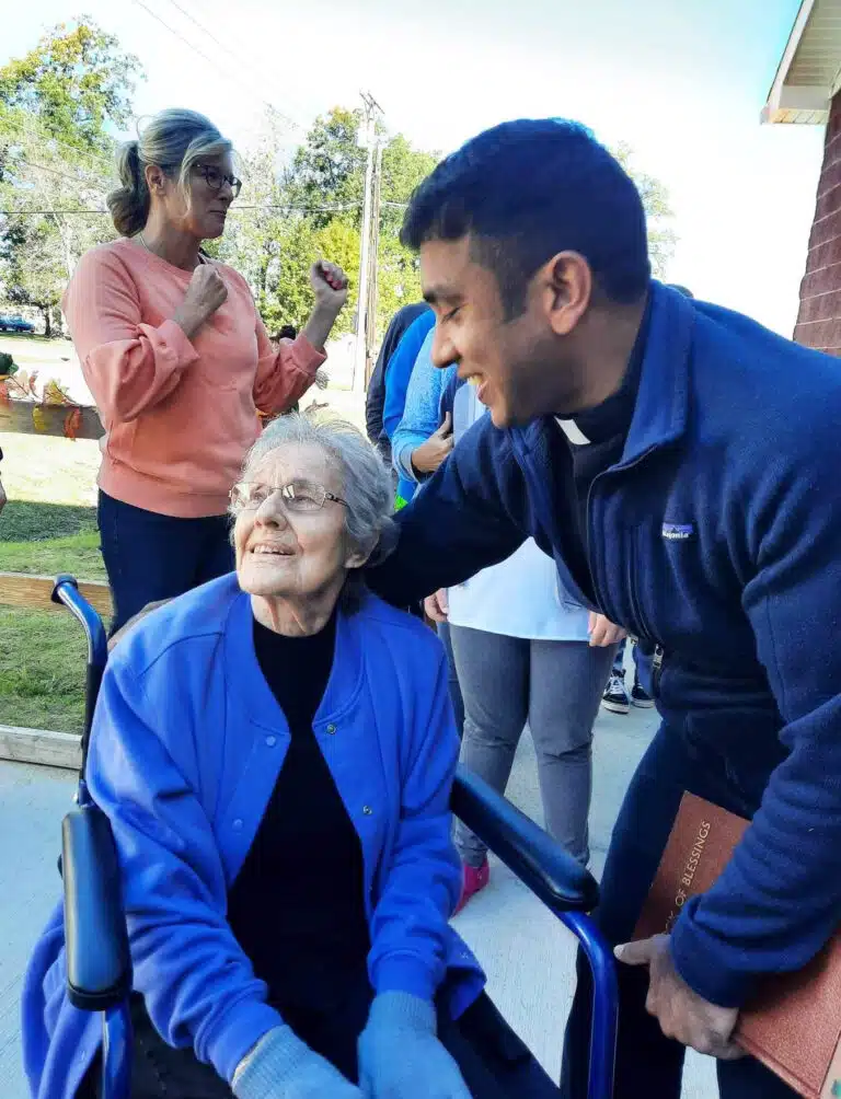 Father Suneesh Mathew visits with Jackie Milliner, the oldest living alumna of St. Paul School. Father Suneesh Mathew visits with Jackie Milliner, the oldest living alumna of St. Paul School.