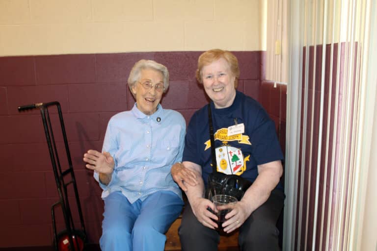 Sister Elaine Burke, left, who served as a greeter at one of the doors, talks to Sister Helena Fischer who volunteered to help the winners retrieve their quilts. Sister Elaine does a lot of quilt binding for her Ursuline community.