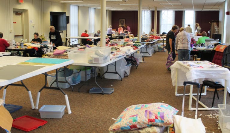 The entire Saint Angela Conference Room in the Retreat Center is occupied by the 21 Quilting Friends who came for the week.